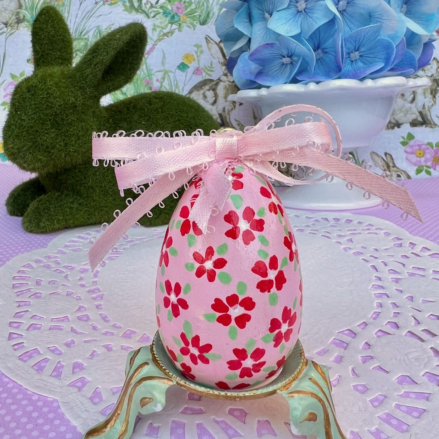 Small Hand Painted Egg Featuring Playful Red Flowers on a Delicate Pink Background
